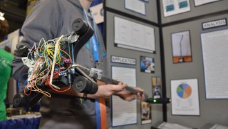 Mary Hood shows off her smart cane. The nest of wires underneath helps power the sensors that help the cane sense obstacles.