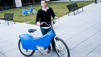 a man standing next to a blue electric bike