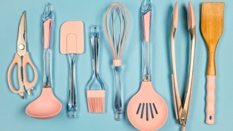 a row of spatulas, tongs, ladles and other kitchen tools with pink silicone pieces
