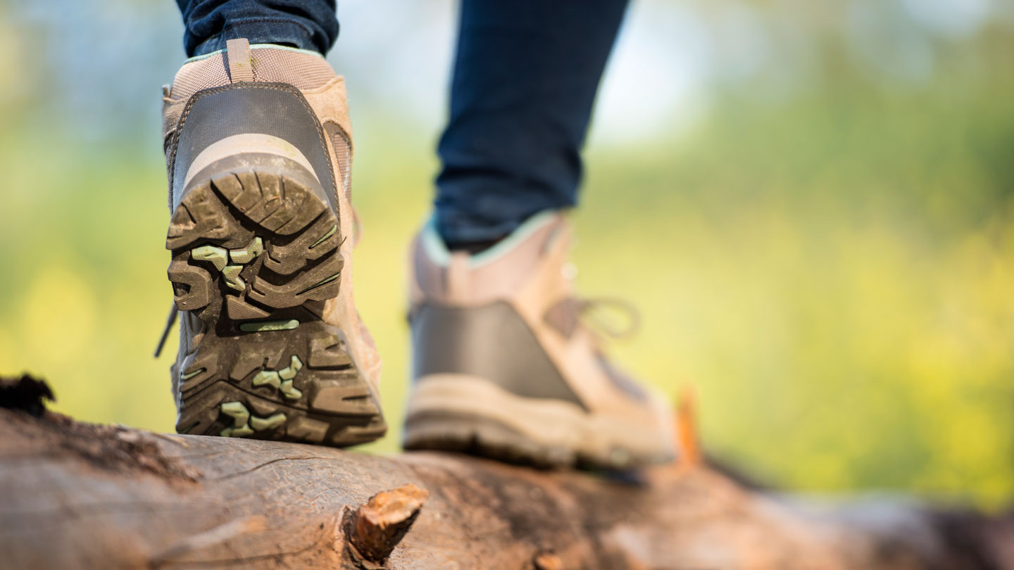 a close up of the back of someone's shoes as they walk across a log shows the bumpy texture of the soles