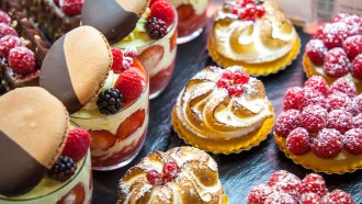 an assortment of French pastries with fruit, chocolate and creme in a display window
