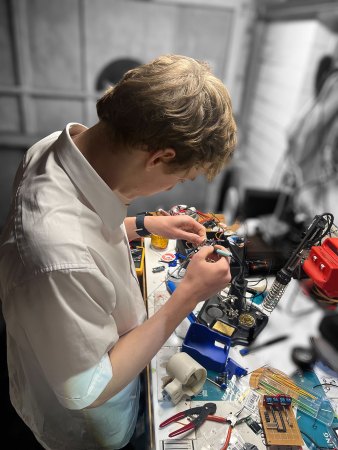Tim soldering the innards of a huggable robot
