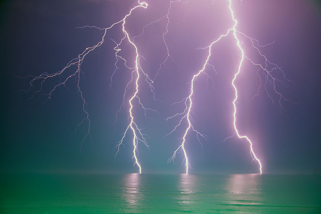 a photo of lightning strikes over water. Could they have started life on Earth?